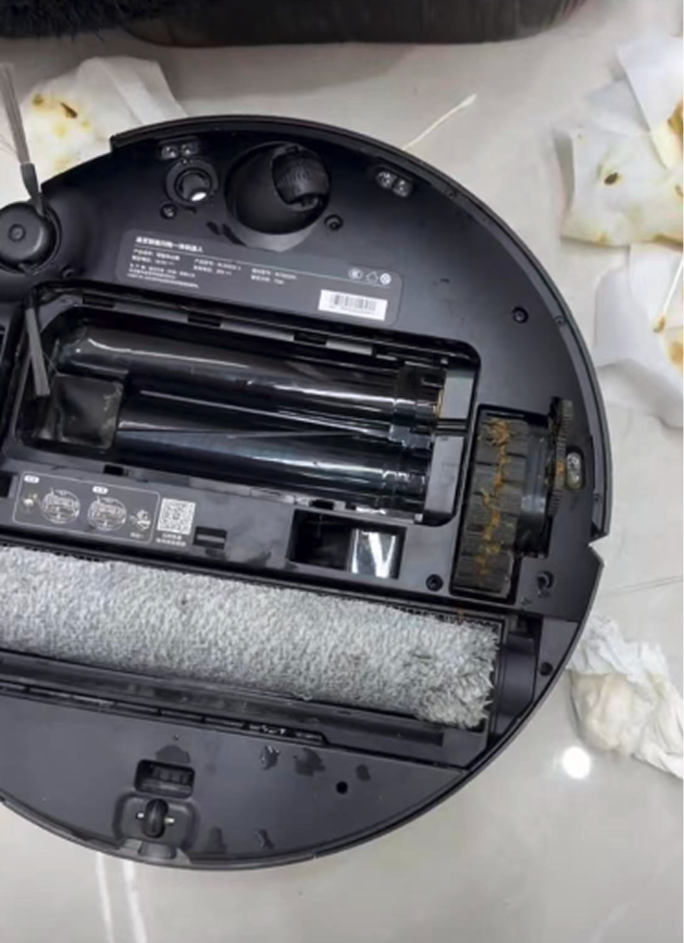 The robot's underside and roller brush caked with pet waste